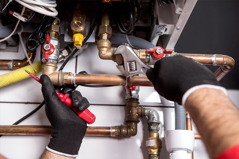 An image of a City View Plumbing, Heating & Air Conditioning journeyman fixes a boiler and furnace in a Minnesota home used for a blog banner