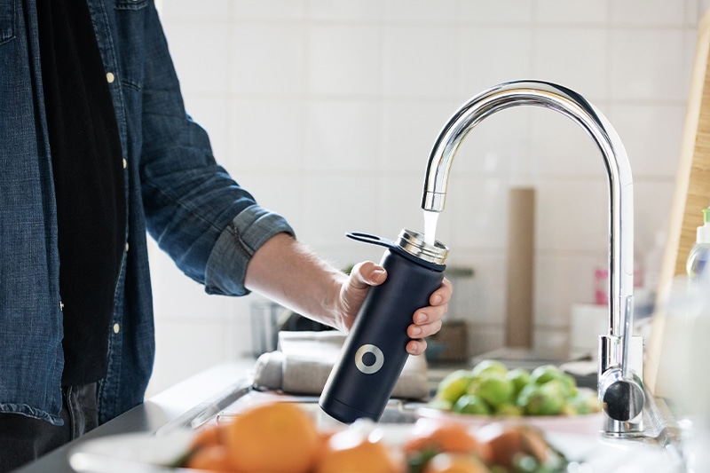 An image of a person fills a water bottle with clear water thanks to water conditioning by City View Plumbing, Heating & Air Conditioning used for a blog banner
